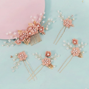 Detailset handgefertigter Brauthaarkämme und Nadeln mit rosa Blüten und Perlen