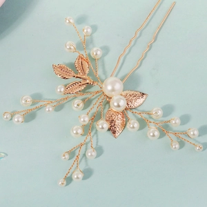 Macro view of bridal hair pin with golden leaves and white pearls for vintage styling