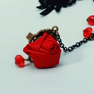 Detailed close-up of a Gothic lace hand chain with red silk rose and bronze metal filigree