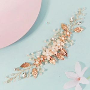 Detailed macro of rose gold bridal hair vine with pearls and fabric flowers