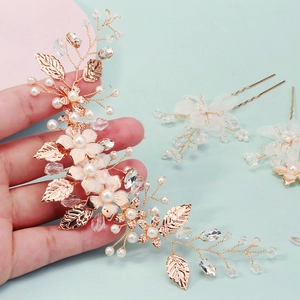 Detail of rose gold bridal hairpiece set with silk flowers, crystals and faux pearls