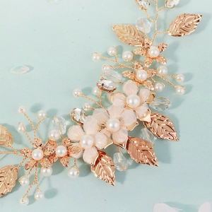 Detailed macro view of bridal hair pin with golden metal leaves and pink fabric petals