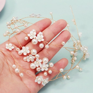 Dettaglio macro di accessorio per capelli fatto a mano in oro con perle e piccoli fiori