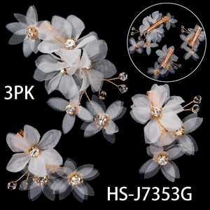 Détail de 3 barrettes à fleurs en maille blanche avec perles dorées et strass brillants