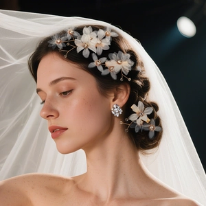 Detailed bridal hair pin featuring handmade white mesh flowers and gold wire pearls