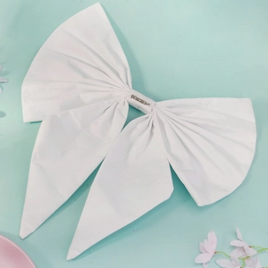 Detail view of large white pleated fabric bow with metal safety pin for wedding dresses