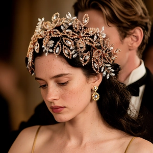 Détail de serre-tête de mariée de luxe avec cristaux et boucles d'oreilles feuille d'or
