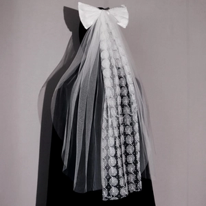 Détail du voile de mariée blanc avec dentelle à roses 3D et grand nœud en satin