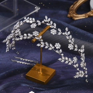 Close-up of silver bridal crown with crystal flower leaves and matching hair pins