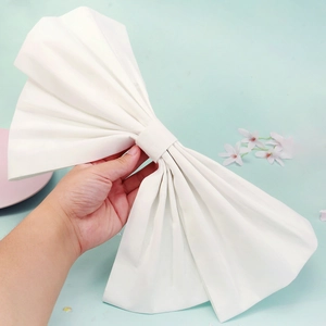 Detail of large white fabric bow brooch accessory with clean texture for wedding dress
