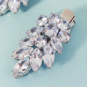 Close-up of leaf-shaped zircon hair clips with marquise cut stones and silver metal base