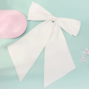 Detail of a large white fabric bow with long ribbons for bridal or evening dress decoration
