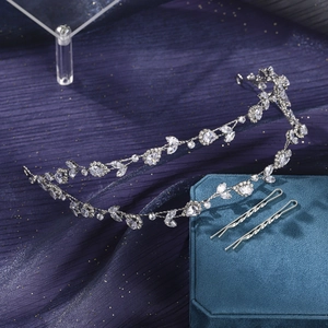 Detail of silver rhinestone headband and wave hairpins on purple satin background