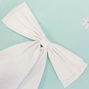 Detail of a large white multilayer fabric bow brooch for wedding dresses and Lolita skirts