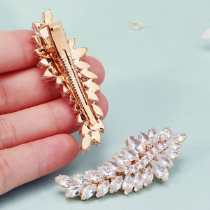 Elegante fermaglio per capelli a piuma dorata con strass scintillanti e chiusura a becco