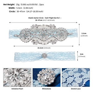 Detail view of light blue bridal garters with handmade rhinestones and pearls on lace
