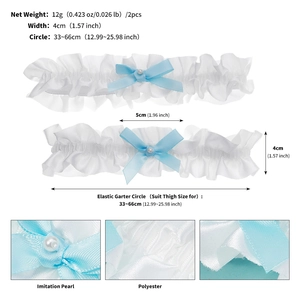 Detailed view of white lace bridal garters with blue bows and imitation pearl accents