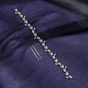 Close-up of elegant silver vine hairpiece with crystals on sparkling purple tulle
