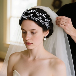 Détail du serre-tête en cristal argenté et boucles d'oreilles assorties sur une mariée