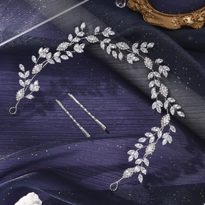 Close-up of silver leaf hair vine with zircon inlay on dark blue silk fabric