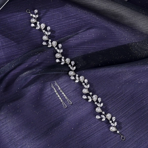 Macro detail of bridal vine headpiece with sparkling marquise crystals on purple fabric
