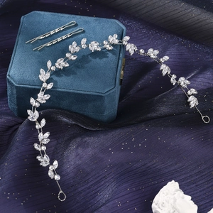 Detail view of crystal leaf headband and wavy hair pins on a blue velvet jewelry box