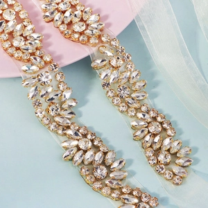 Close-up of sparkling marquise crystal bridal belt with gold setting and pink mesh