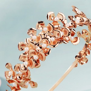 Vue macro d'un serre-tête de mariée avec fleurs en métal doré et perles blanches