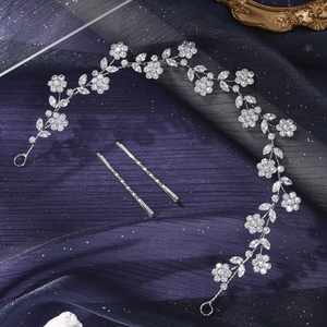 Detail of silver bridal hairband with crystal flowers and leaves on blue tulle background