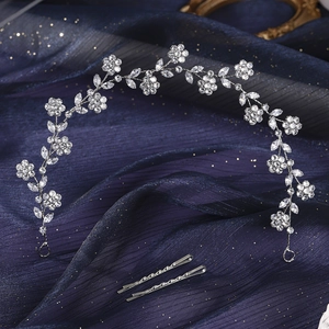 Close-up of sparkling floral rhinestone headband and matching silver hair clips on tulle