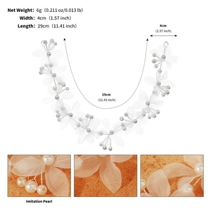 Détail de fleurs en tissu blanc et perles d'imitation sur une vigne de cheveux de mariage