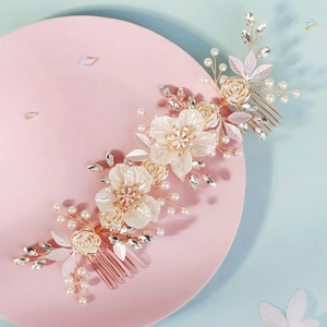 Elegant bridal hair comb with white shell flowers, pearls, and crystals in golden setting
