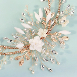 Dettaglio ravvicinato di fascia per capelli da sposa fatta a mano con fiori e perle