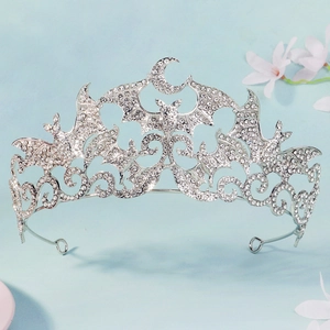 Detail of gothic bat and moon crown with sparkling rhinestones on light blue texture