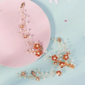 Détails de la coiffe de mariée en or rose avec perles délicates et fleurs métalliques