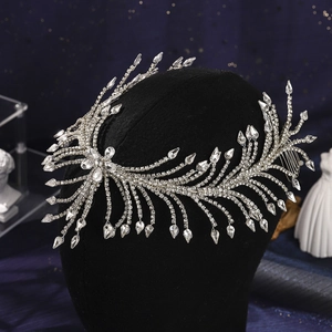 Dettaglio di un copricapo da sposa in argento con piume di strass su sfondo scuro