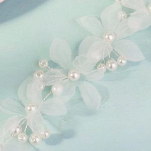 Détail des pétales en maille blanche et perles sur le bandeau de mariée fait main
