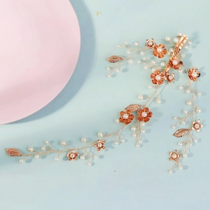 Détail du bandeau de mariée avec feuilles dorées, perles blanches et fleurs en métal