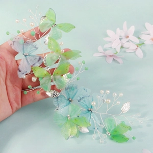 Detail of forest style butterfly hairband with pearls and green tulle butterfly wings