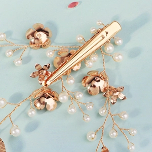 Épingle à cheveux mariée dorée avec feuilles en métal, perles et détails floraux
