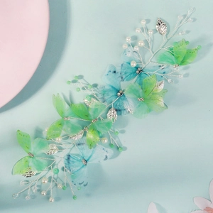 Detail of handmade bridal hair vine with green gradient butterflies and pearls