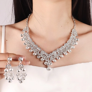 Detailed view of silver bridal jewelry set with V-shaped rhinestone necklace and earrings