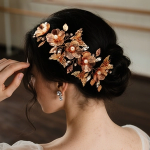 Accessorio per capelli da sposa dorato con perle bianche e cristalli su una modella