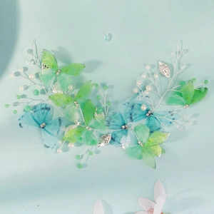 Detail of handmade butterfly hairband with soft green organza wings and white pearls