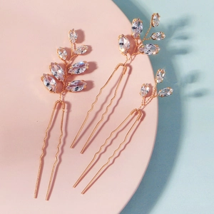 Détail d'épingles à cheveux or rose avec cristaux marquise en design de feuille pour mariée