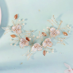 Détail du bandeau de mariée en fil d'or avec pétales blancs et papillons en cristal