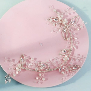 Silver bridal hair vine with pearls and crystals on a pink plate for wedding styling