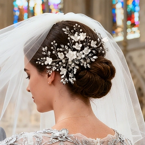 Close-up of handmade bridal hair comb with pearls, crystals and white fabric flowers