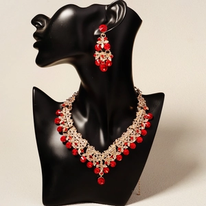 Detailed view of red pear-cut crystal jewelry set on a black mannequin for weddings