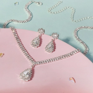 Détail d'une parure de bijoux avec collier et boucles d'oreilles en strass poire